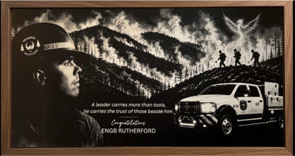 A framed black and white memorial print featuring a firefighter in profile, a wildfire scene with smoke and trees, a rescue truck, and the text 'Congratulations ENGB RUTHERFORD'.